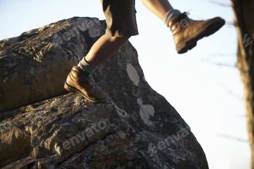 Preview: Hiker In Shorts And Hiking Boots Leaping From Rock, Low Section, Close-Up (Blurred Motion)