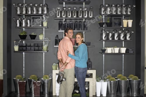 Preview: Couple Standing Beside Cacti Display In Shop, Man Holding Watering Can, Smiling, Rear View, Portrait
