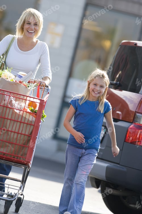 Preview: Mother With Daughter Pushing Grocery Cart Full Of Groceries