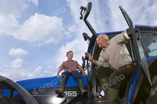 Preview: Farmer And Grandson Sitting On Tractor