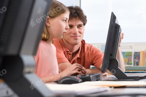 Preview: Male Teacher Helping Female High School Student Computer In Class