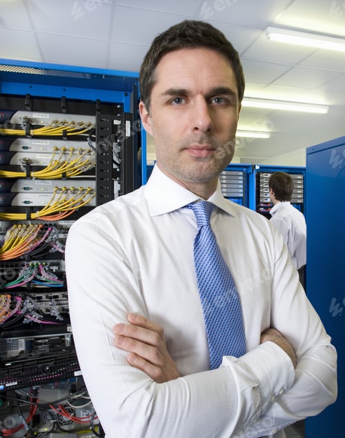 Preview: Portrait Of Serious Businessman With Arms Crossed In Network Server Room