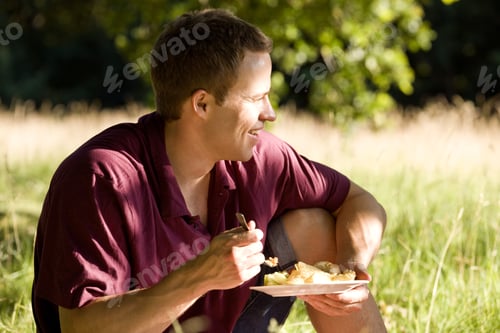Preview: A Young Man Sitting On The Grass, Eating