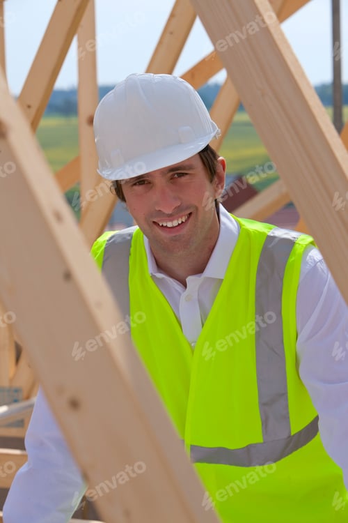 Preview: Architect In Hard Hat And Safety Vest On House Construction Site Smiling At Camera