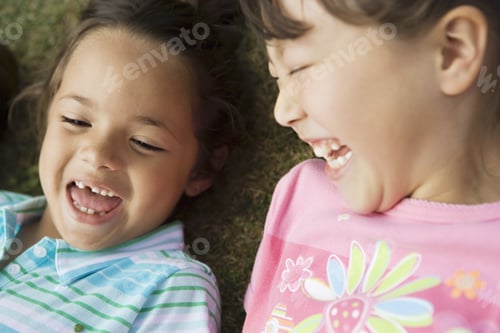 Preview: Two Girls (3-5) Lying On Grass, Laughing, Close-Up, Overhead View