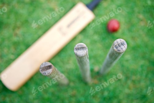 Preview: Overhead View Looking Down On Cricket Stumps With Bat And Ball Out Of Focus On Grass