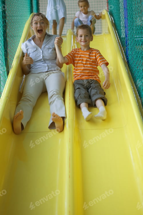 Preview: Portrait Of A Boy With A Mid Adult Woman Sliding On A Slide