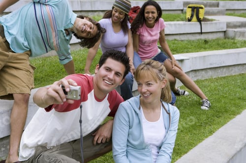 Preview: Teenage Boy Taking Photograph Of Friends With Digital Camera, Smiling