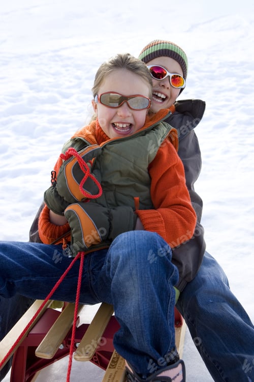 Preview: Boy And Girl On Sled In Snow, Wearing Sunglasses, Smiling, Portrait