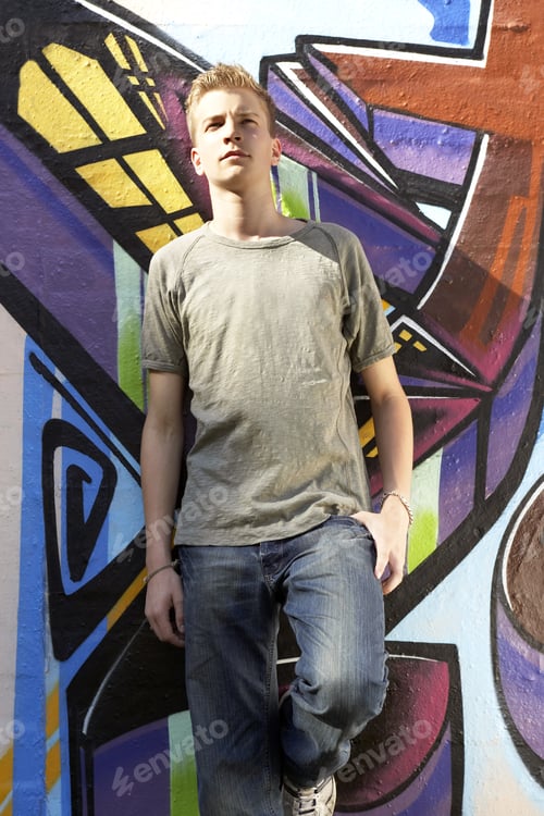 Preview: A Teenager Standing Against A Mural.