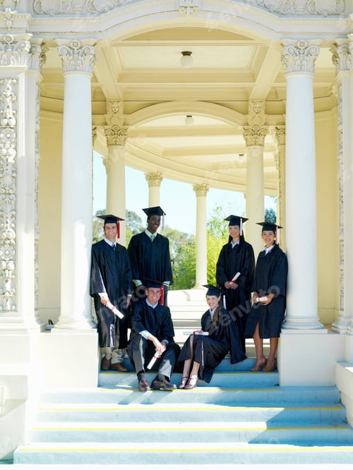 Visualização: Estudantes universitários no dia da formatura em bonés e vestidos com diplomas