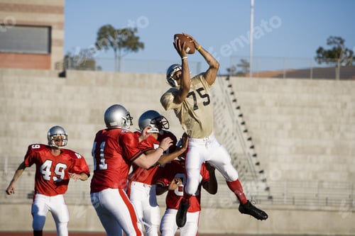 Preview: Opposing American Football Players Competing For Ball During Competitive Game, Offensive Receiver