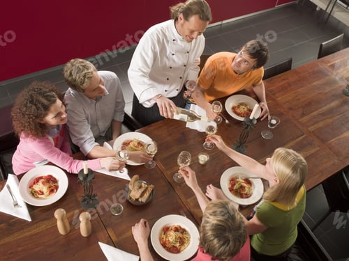 Preview: High Angle View Of A Male Chef Serving Wine At The Dining Table