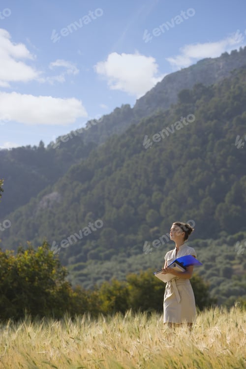 Preview: Businesswoman With Paperwork In Rural Field