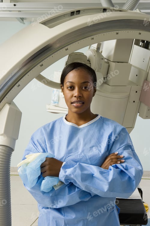 Preview: Female Doctor In Blue Surgical Scrubs Standing Beside Hospital Medical Scanner, Smiling, Portrait