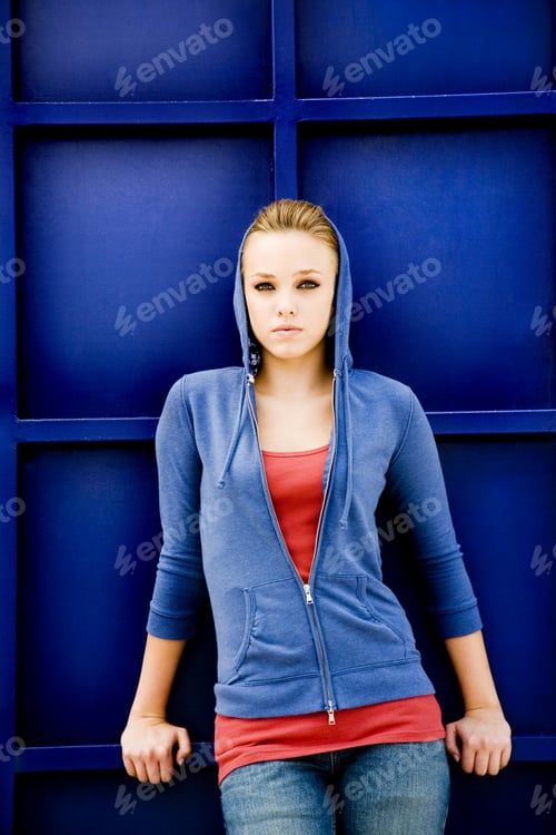Preview: Portrait Of A Girl Leaning Against A Blue Painted Wall