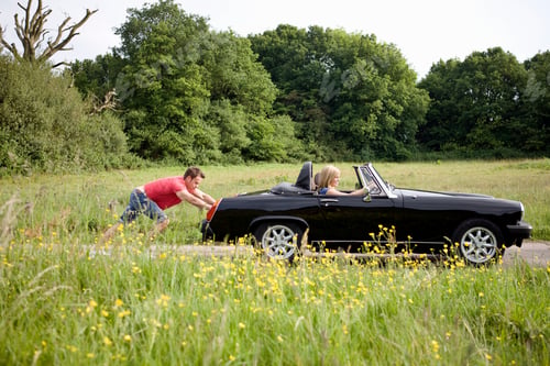 Preview: Man Pushing Woman In Broken Down Classic Sports Car On Country Road