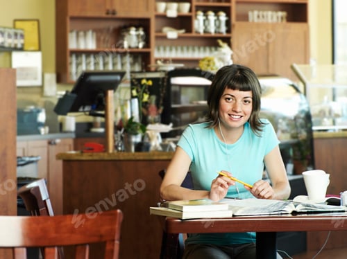 Preview: Portrait Of Female Student Studying In Cafe Working At Table Listening To Mp3 Player And Smiling At