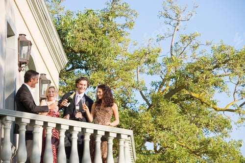 Preview: Four Friends Celebrating Drinking Champagne On Outdoor Balcony