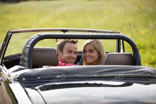 Preview: A Young Couple In A Black Sports Car Smiling