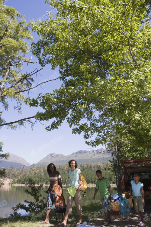 Preview: Family Unloading Provisions From Parked Suv On Lakeside Camping Trip, Smiling