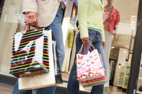 Preview: Couple With Shopping Bags Walking Past Clothes Fashion Shop Window In Retail Mall