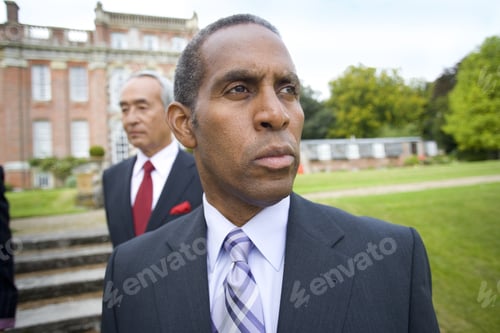 Preview: Businessman By Colleagues In Grounds Of Manor House, Close-Up