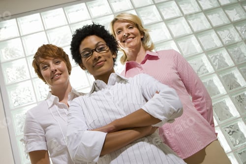 Preview: Three Businesswomen By Glass Block Wall, One With Arms Crossed, Smiling, Portrait, Low Angle View