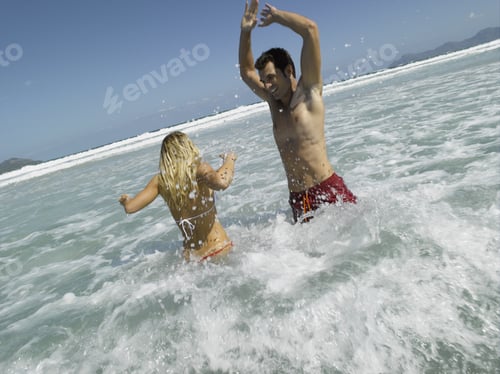 Preview: Mid Adult Couple Splashing Water In The Sea