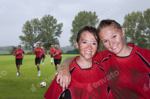Preview: Portrait Of Muddy Teenage Soccer Teammates Hugging And Smiling