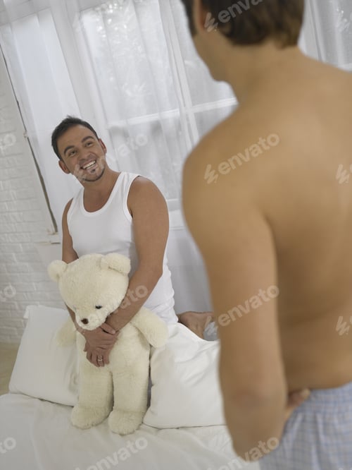 Preview: Young Man Kneeling On The Bed And Looking At Another Young Man