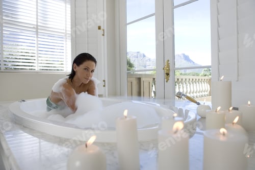 Preview: Woman Enjoying a Relaxing Bubble Bath with Candles