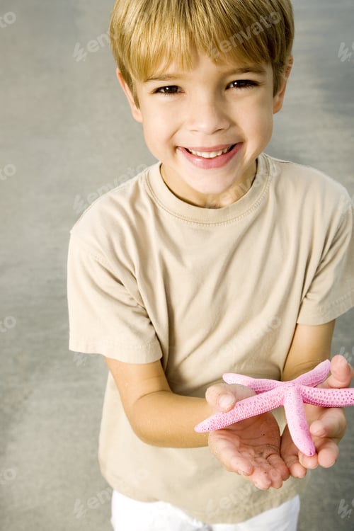 Preview: A Young Boy Holding A Starfish