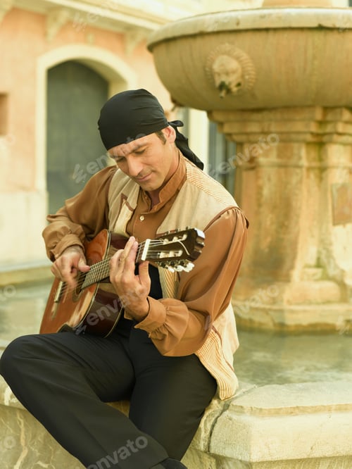 Preview: Mid Adult Man Playing A Guitar And Looking Down