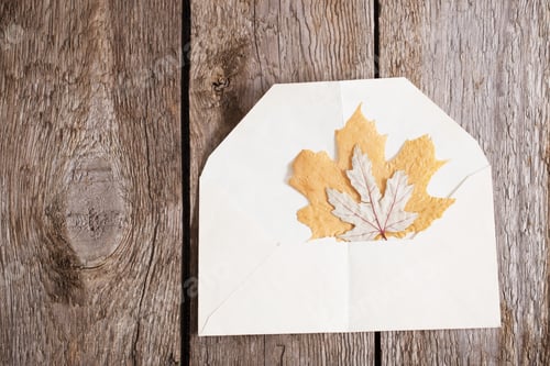 Preview: Autumn Leaves In Envelope On Wooden Background