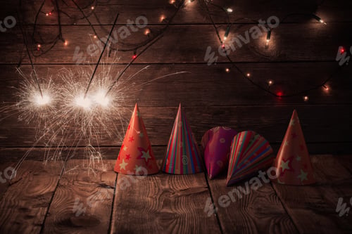 Preview: Party Hats And Sparkler On Old Wooden Background