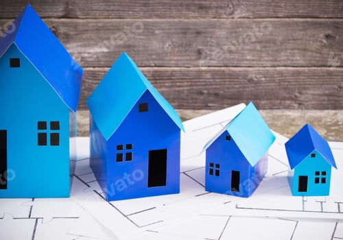 Preview: A Paper Houses Stands Over A Wooden Background