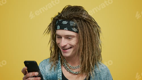 Preview: Smiling Stylish Man Using Smartphone On Yellow Background. Portrait Of Positive Guy Browsing