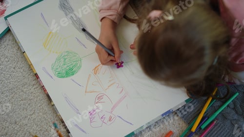 Preview: Top View Unknown Little Girl Drawing Picture With Colored Pencils At Home. Unrecognizable Kid Girl