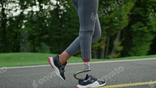 Preview: Smiling Runner With Artificial Limb Exercising In Park. Sportswoman Jogging On Running Surface In