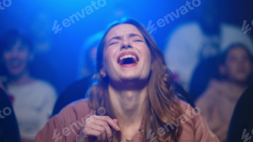 Preview: Happy Female Model Laughing With Funny Moment In Dark Hall. Portrait Of Beautiful Girl Watching