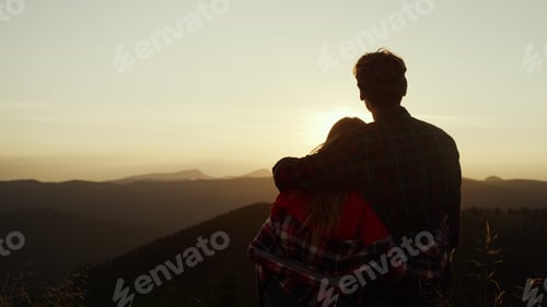 Preview: Back View Romantic Couple Looking Sun Setting Behind Mountain. Loving Man And Woman Enjoying Sunset