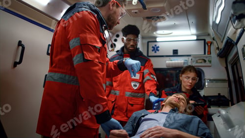 Preview: Multi Ethnic Paramedics Checking Man Pulse On Stretchers In Emergency Car. Female And Male Doctors