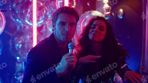 Preview: Smiling Couple Performing Song At Party In Night Club. Young Man And Woman Singing At Karaoke On