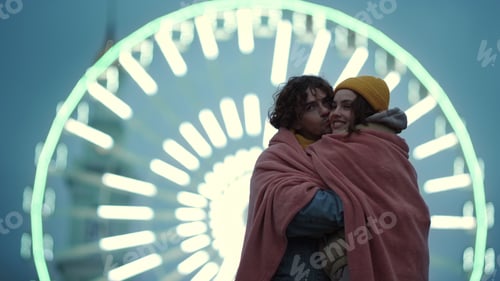 Preview: Love Couple Hugging Against Illuminated Ferris Wheel In City Center. Affectionate Man Kissing Woman