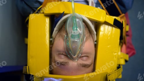 Preview: Overhead Injured Man In Oxygen Mask Lying On Stretchers In Ambulance Car. Paramedics Hands In