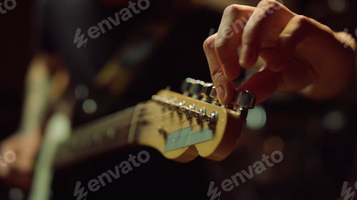 Preview: Unrecognizable Man Tuning Acoustic Guitar In Music Studio. Macro Musician Hand Turning Knobs On
