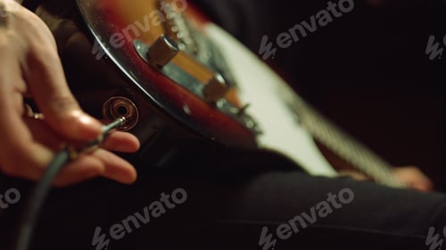 Preview: Closeup Man Hand Sticking Plug To Guitar In Concert Hall. Unrecognizable Person Connecting