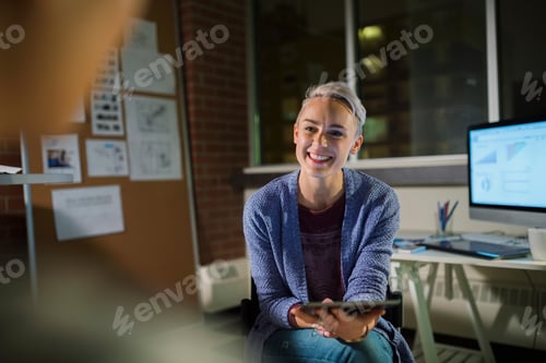 Preview: Businesswoman With Digital Tablet Working Late In Office