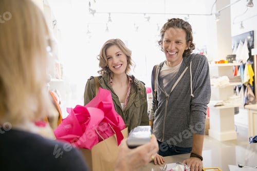 Preview: Couple Using Credit Card Reader In Shop